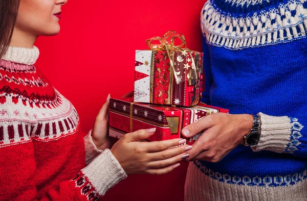 Strzał studio człowieka w islandzkiej sweter, dając jego dziewczyna pudełeczka. Boże Narodzenie czy nowy rok uroczystości koncepcja. — Zdjęcie stockowe