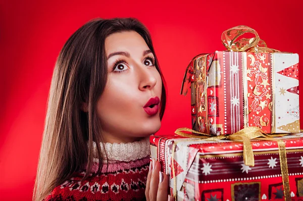 Prise de vue en studio d'une jeune femme en pull islandais tenant des coffrets-cadeaux. Noel ou Nouvel An concept de célébration . — Photo