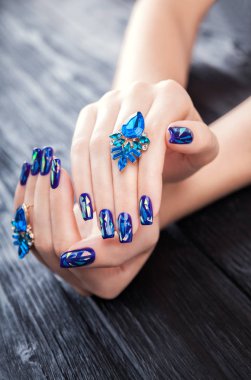 Siyah arka plan üzerinde mücevher ile parçalanmış cam mavi manikür