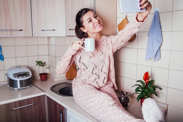 Молодая женщина завтракает на кухне и делает селфи — стоковое фото