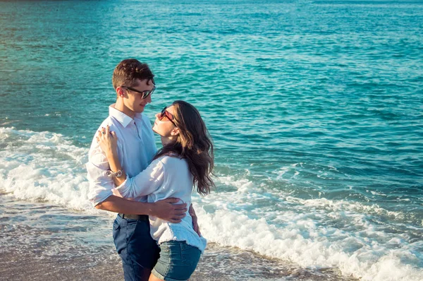 Unga lyckliga paret kramas på tropical beach — Stockfoto