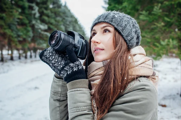 Mladý fotograf fotí zimní les — Stock fotografie