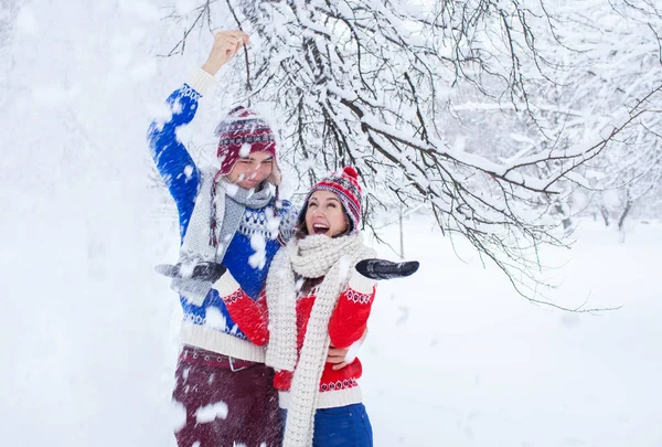 Pareja sacudiendo rama de abeto con nieve — Foto de Stock