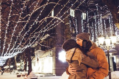 Genç çift öpücük gece tatil kış aydınlatma altında