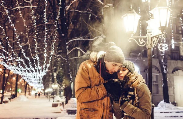 Young couple drinking hot tea in the city center under illumination — Stock Photo, Image