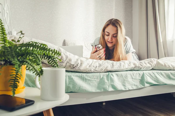 Smiling young woman playing with a little hedgehog — Stock Photo, Image