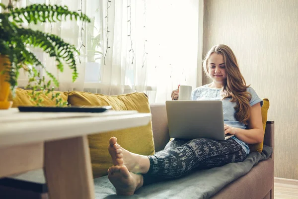 Young woman using her laptop in the livingroom — Stock Photo, Image