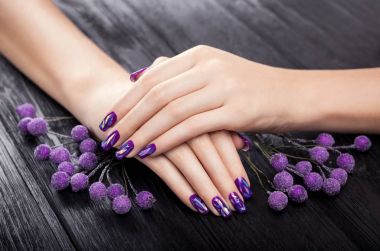 Siyah arka plan üzerine parçalanmış cam mor manikür