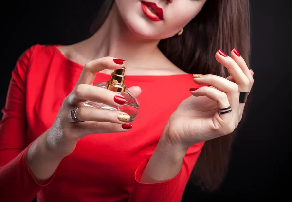 Woman applying perfume on her wrist on black background Stock Picture