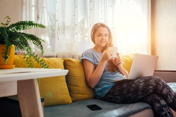 Young woman using her laptop in the livingroom — Stock Photo, Image