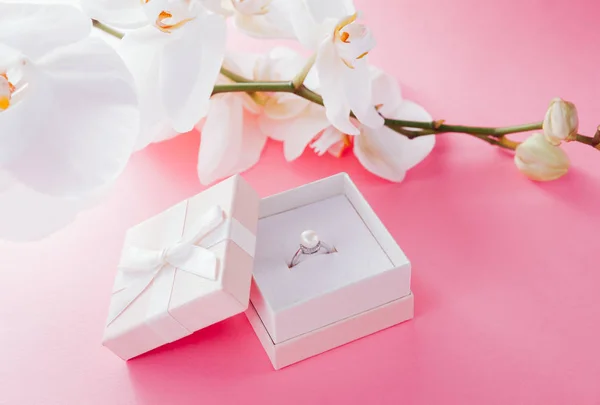 Bague en argent avec perle dans la boîte cadeau avec orchidée blanche — Photo