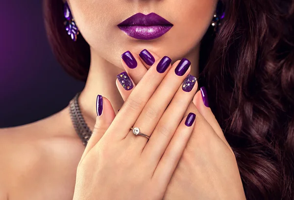 Hermosa mujer con maquillaje perfecto y manicura púrpura con joyas — Foto de Stock