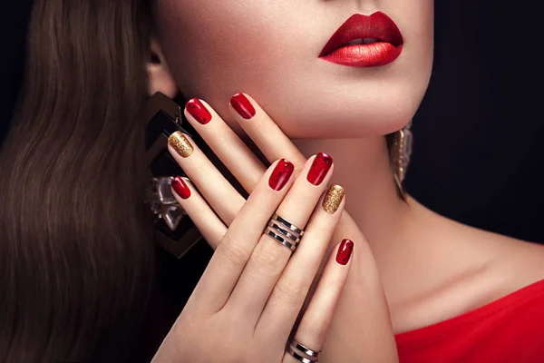 Mulher bonita com maquiagem perfeita e manicure vermelho e dourado usando jóias — Fotografia de Stock