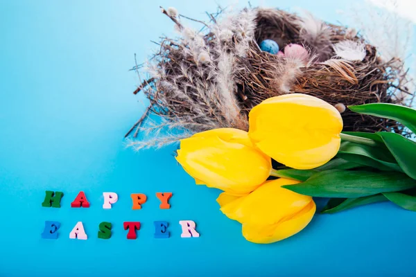 ハッピー イースター。巣の卵と黄色のチューリップ — ストック写真