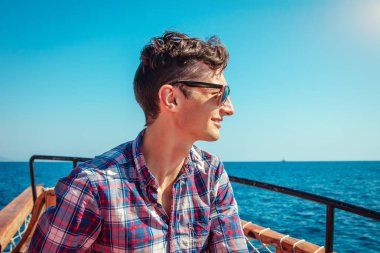 Genç adam bir ahşap yat deniz görünümü sahiptir