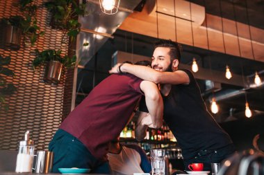 Çok ırklı erkekler onların arkadaşı lounge Café toplantı. Gerçek duyguları en iyi arkadaşlar birbirlerine görmekten mutlu.