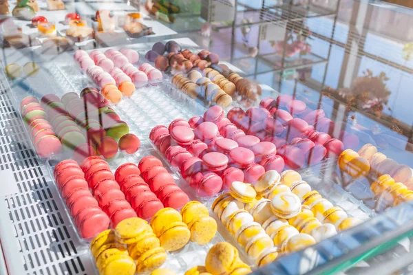 Kafe vitrin üzerinde renkli macaroons ürün yelpazesine. Macaron tatlar çeşitli. Deposundaki tatlı bademli kek. — Stok fotoğraf