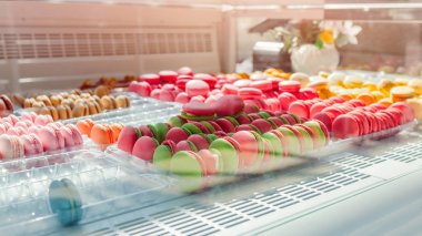 Kafe vitrin üzerinde renkli macaroons ürün yelpazesine. Macaron tatlar çeşitli. Deposundaki tatlı bademli kek.