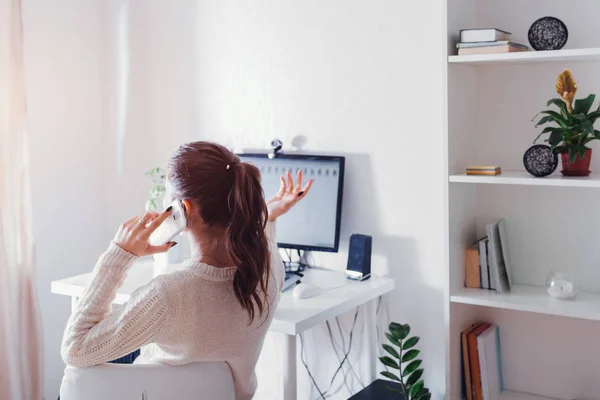 Workspace of woman freelancer. Woman works on computer at home and talks on the phone. — Stock Photo, Image