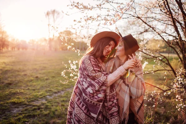 Madre di mezza età e sua figlia adulta che si abbracciano nel giardino fiorito. Il concetto della festa della mamma. Valori familiari — Foto Stock
