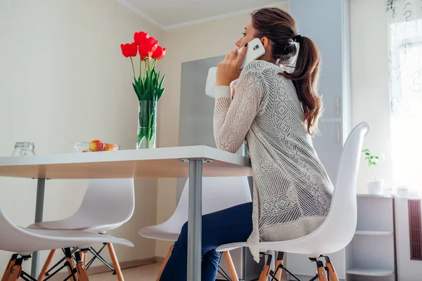 Junge Frau entspannt sich und telefoniert in der Küche. modernes Küchendesign — Stockfoto