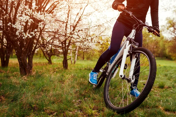 Genç kadının Bisiklet bahar orman içinde bir yola. Helathy yaşam tarzı kavramı. Bisiklet tekerleği Close-Up
