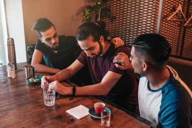 Destekleyici genç erkekler kırıklar dostlarını teşvik. Arap çocuklar restoranda neşelendirmek. Dostluk kavramı.