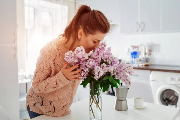 Libre de alergia. Mujer feliz oliendo lila en la cocina moderna. Concepto de alergia estacional . — Foto de Stock