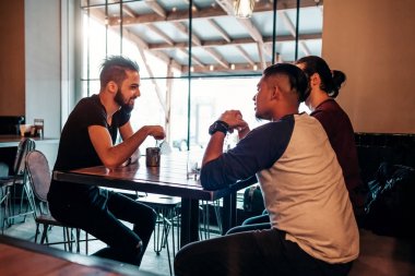 Loft kafede asılı Arap delikanlı. Orta Doğulu insanlar konuşmaya ve lounge barda eğleniyor ve içki içiyorduk. Dışarı soğuk ve rahatlatıcı arkadaşlar