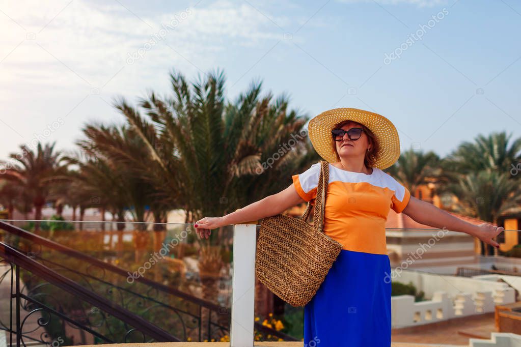 Senior woman walking on hotel territory in Egypt. Summer tropical vacation. Stylish fashionable look