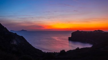 Deniz kenarında ve dağ manzaralı Santorini gün batımı. Akrotiri, Yunanistan. Gece manzarası. Seyahat kavramı