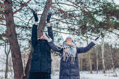 Kış aktiviteleri. Kışın ormana kar atan bir çift. İnsanlar rahatlıyor ve dışarıda eğleniyorlar.