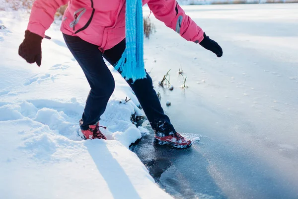 Gelo fino perigoso. Mulher corre o risco de pisar na superfície do rio congelado no inverno. Cuidado, água insegura, possibilidade de queda — Fotografia de Stock