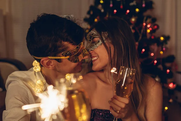 Noël et Nouvel An concept de fête. Couple en amour brûlant des étincelles par arbre de Noël illuminé avec champagne . — Photo
