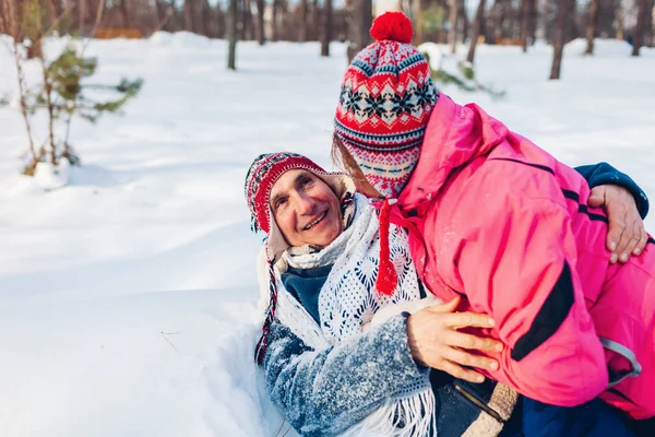 Valentine's Day. Senior couple hugging in winter forest. Man and woman lying in snow and having fun — Stock Photo, Image