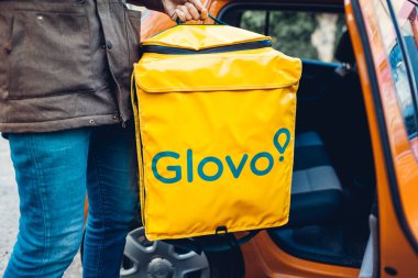 Lviv, Ukrayna 13 Ocak 2020 Glovo teslimat çantası. Erkek işçi termoçanta alır. Teslimat şirketi.