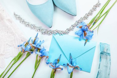 Düğün davetiyesi. Çiçekler, gelin ayakkabıları, parfüm ve mücevherlerle çevrili. Aqua menthe 'de gelinin sabahı