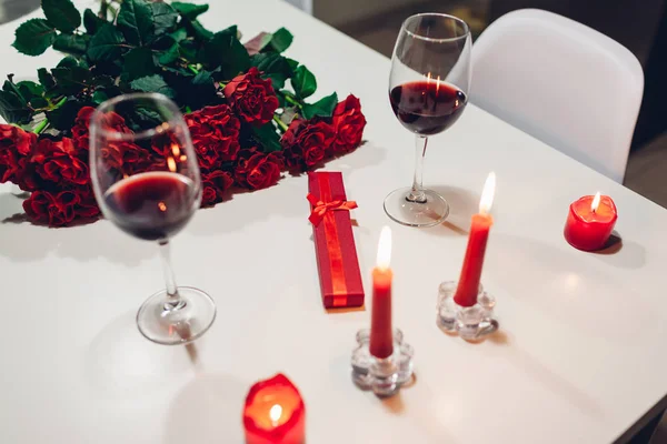 Святкування Дня святого Валентина з вином, свічками, трояндами і подарунковими коробками вдома. Романтична атмосфера для коханців — стокове фото