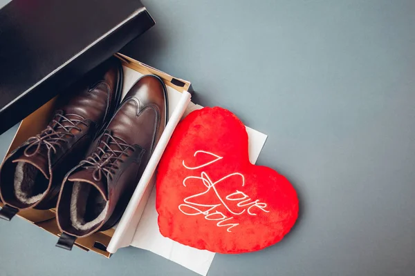 Shoes boots in box for Valentines day as present for man with red heart I love you. Male winter fashion. Footwear