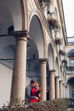 Sevgililer günü romantik randevusu. Erkek sarılan kız arkadaş. İtalyan bahçesinde yürüyen çift Lviv 'de güllerle