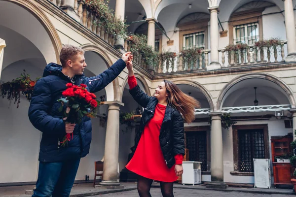 Walentynki romantyczna randka. Chłopak i dziewczyna tańczą. Para spacerująca po włoskim podwórku we Lwowie z różami — Zdjęcie stockowe