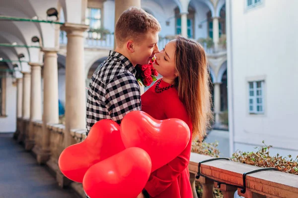 Alla hjärtans dag romantisk dejt. Man kramar, kysser flickvän. Par går på italiensk gård i Lviv med rosor — Stockfoto