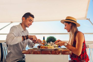 İki kişilik romantik balayı yemeği. Yemek yiyen ve içki içen bir çift. Kafede Sevgililer Günü Yemeği