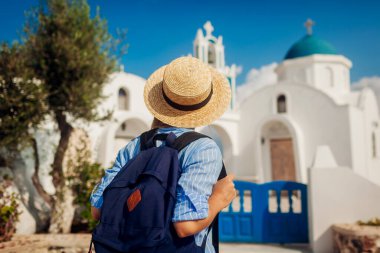 Santorini gezgini Akrotiri 'de Yunan kilise mimarisini keşfediyor. Tatil boyunca gezen kadın turist