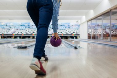 Bowling maçı. Kulüpte bowling oynarken eğlenen bir kadın. Bacaklarını ve ayakkabılarını kapat.