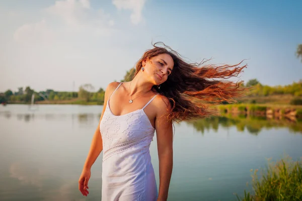 Den žen. Mladá žena se cítí volný a šťastný chůze a točení kolem letní řeky — Stock fotografie