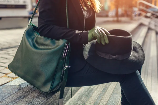 Accesorios femeninos de moda. Mujer con bolso de mano gree con guantes y sombrero negro al aire libre . — Foto de Stock