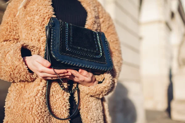 Moda feminina. Acessórios de primavera. Mulher elegante vestindo casaco e segurando bolsa preta ao ar livre. Vestuário e bolsa — Fotografia de Stock