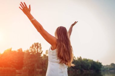 Olgun orta yaşlı kadın, bahar parkında mutlu ve özgür hissederek gün batımını seyrediyor. Kıdemli kadın manzaraya bayılır. Uyum ve denge