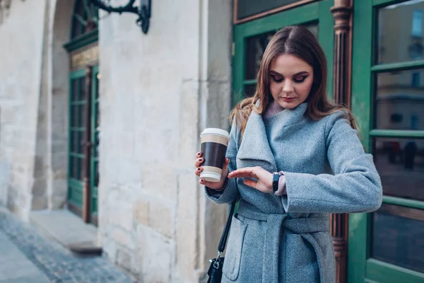 손으로 커피를 마시는 바라보는 거리에서 친구를 기다리고 여성의 — 스톡 사진